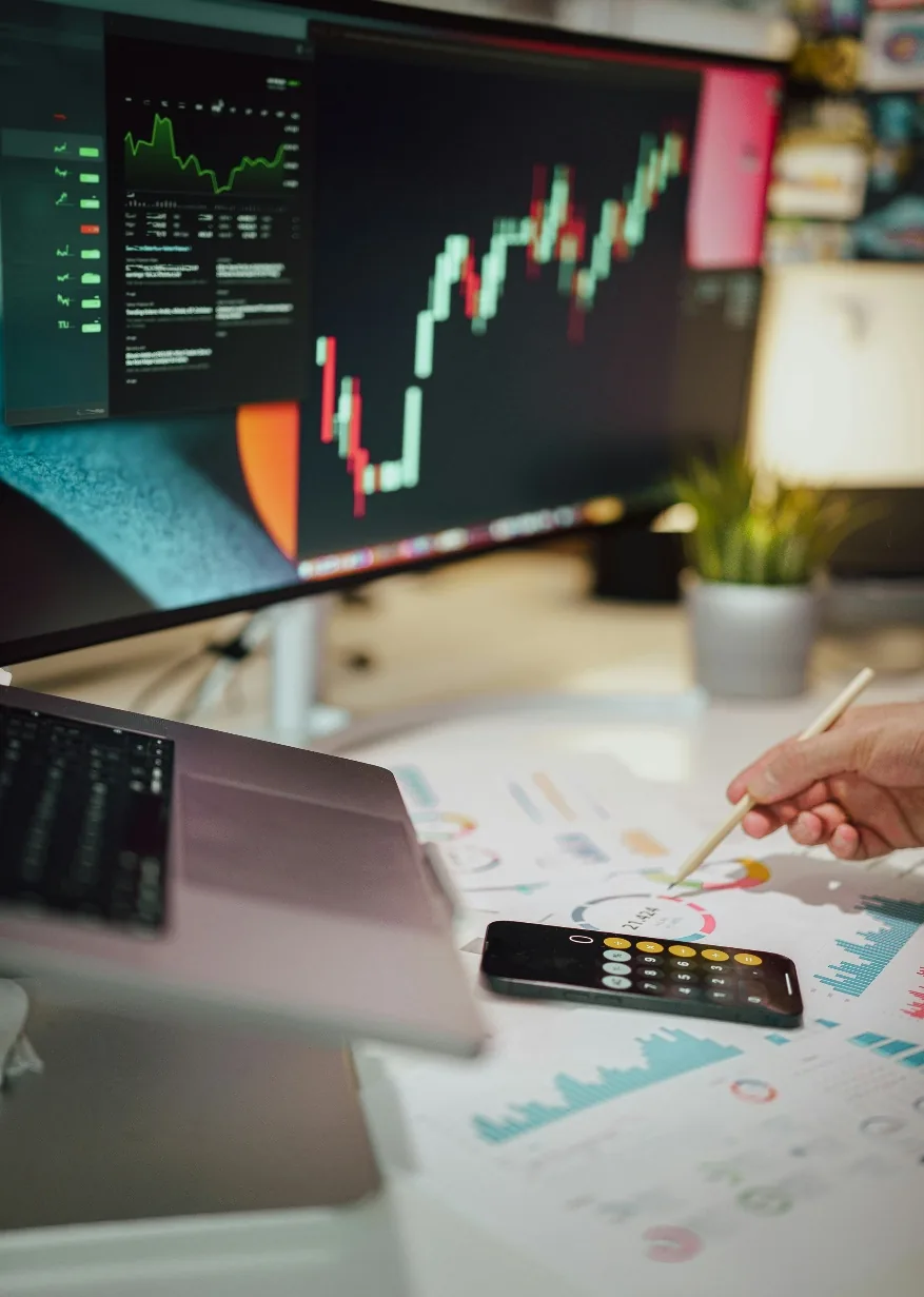 Economic analysis shown on digital screens and paper
