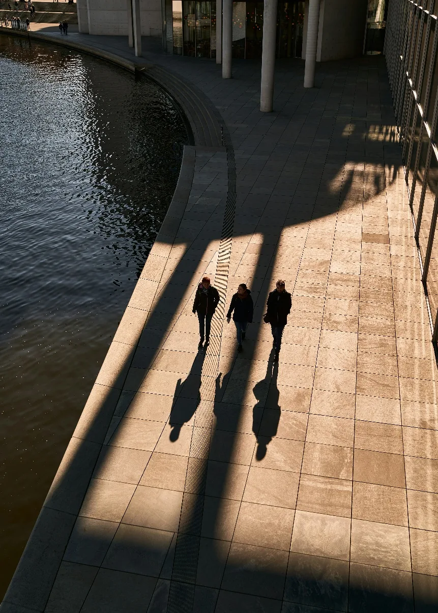 People walking together beside water